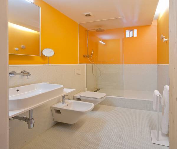 Эффектная ванная «Tyche-bathroom» с теплой оранжево-белой отделкой с фото