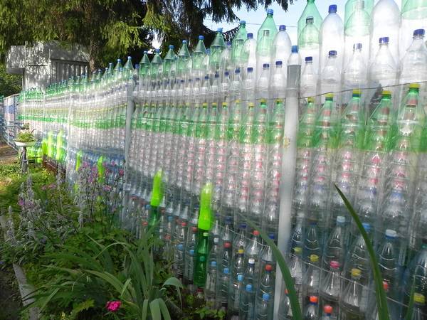 Забор из пластиковых бутылок - фото